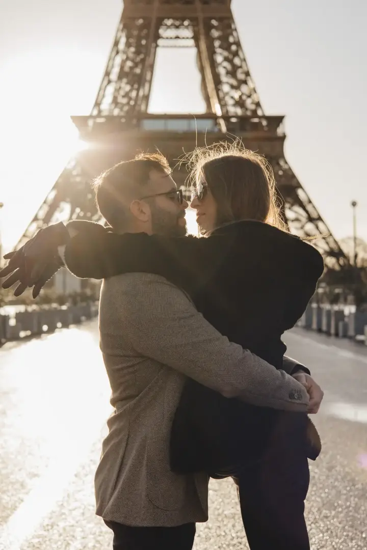Couple kissing backlit Eiffel Tower silhouette golden Paris