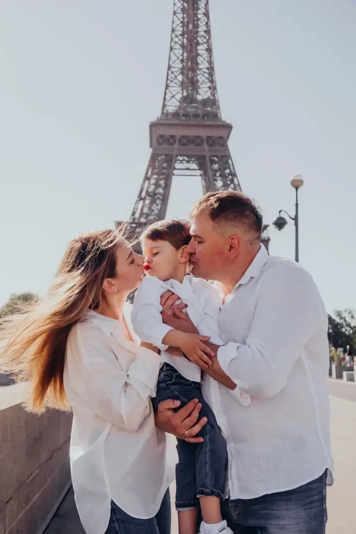 Parents kissing son Eiffel Tower Paris tender moment