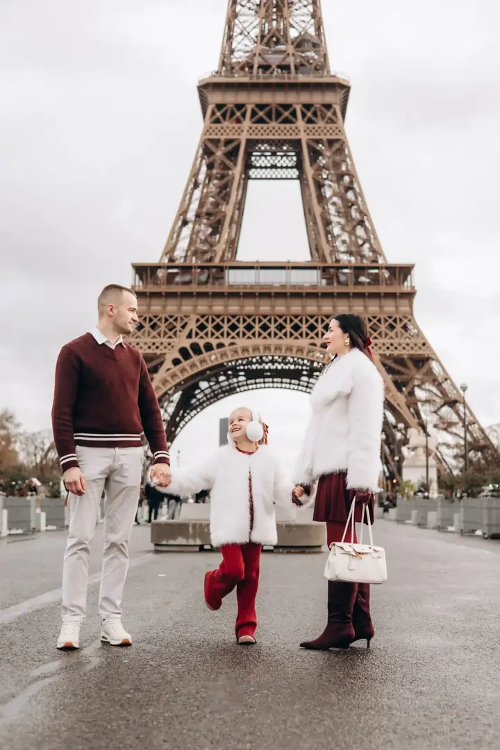 Family running Eiffel Tower Paris joyful